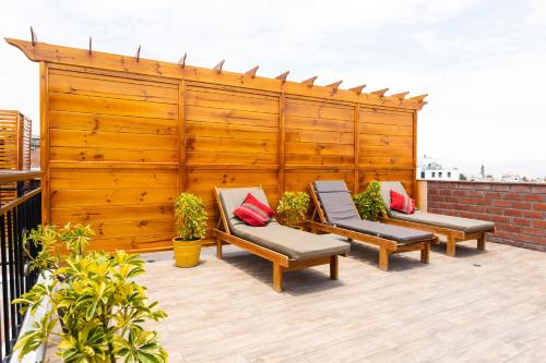 a patio with three chairs and a wooden fence at El Portal De San Lázaro in Arequipa