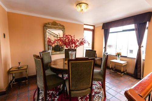 a dining room with a table and chairs and a mirror at El Portal De San Lázaro in Arequipa