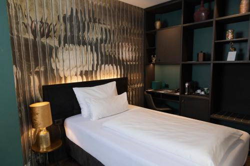 a bedroom with a white bed and a desk at Aiola Living Graz in Graz
