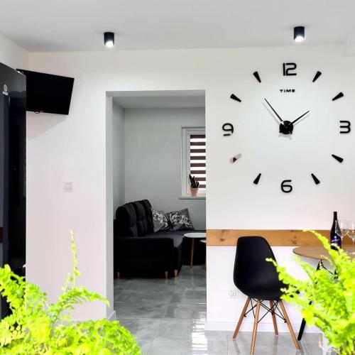 a living room with a clock on the wall at APARTAMENT PRZY RONDZIE in Kłodzko