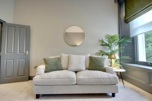 a living room with a white couch and a mirror at Orange Grove Hotel & Gardens in Southampton
