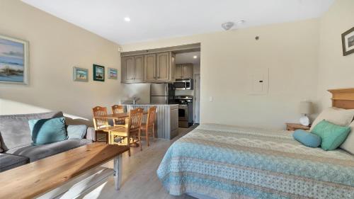 a bedroom with a bed and a couch and a kitchen at Windward Shores in Amagansett