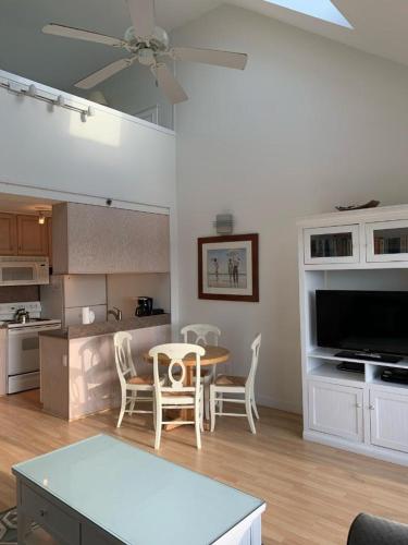 a living room with a table and a kitchen at Windward Shores in Amagansett