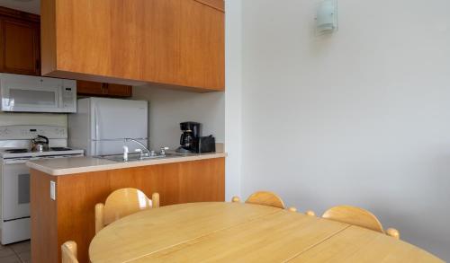 a kitchen with a wooden table and a kitchen with a sink at Windward Shores in Amagansett