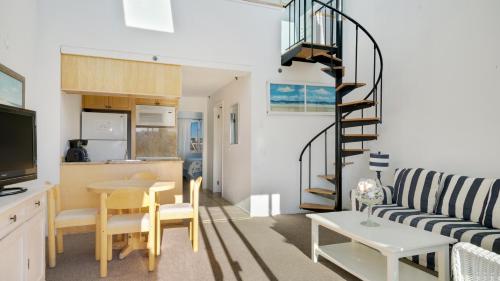 a living room with a spiral staircase in a house at Windward Shores in Amagansett
