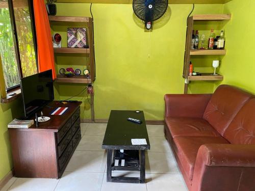 
a living room filled with furniture and a tv at Bungalows Kire in Puerto Viejo
