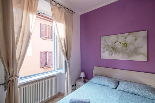 - une chambre avec des murs violets, un lit et une fenêtre dans l'établissement Casa Paola - Downtown Cernobbio, à Cernobbio