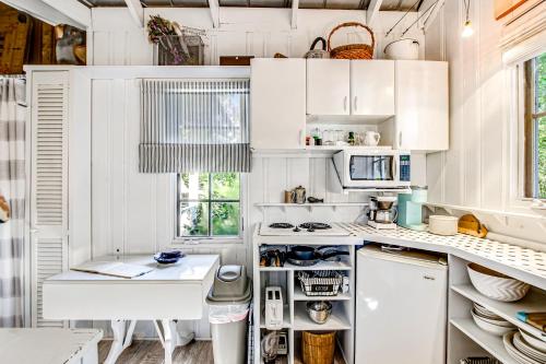 a kitchen with white cabinets and a stove top oven at Baby Breezy Tree House in Demere Park