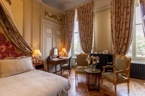a bedroom with a bed and two chairs and a desk at Bayard Bellecour in Lyon