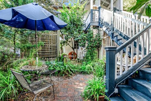 a patio with a table and an umbrella and stairs at Baby Breezy Tree House in Demere Park