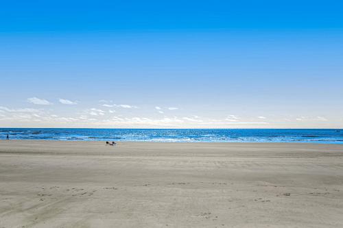 a beach with people on the sand and the ocean at Baby Breezy Tree House in Demere Park