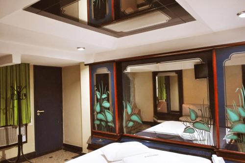 Hotel Xanadu - Adults Only في ريو دي جانيرو: غرفة بسرير مع لوحة على الحائط