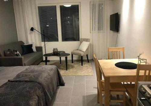 uma sala de estar com uma cama, uma mesa e um sofá em Ski Studio Levi em Levi