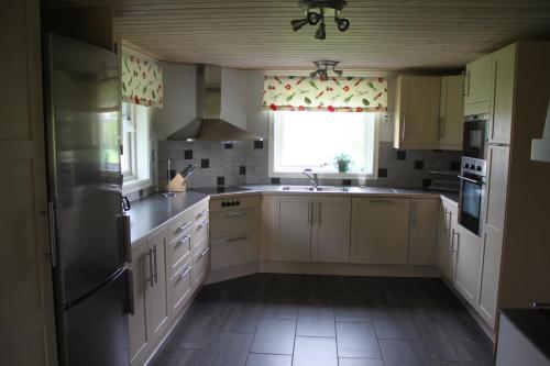 a kitchen with white cabinets and a large window at Flahult Holiday Home in Hok