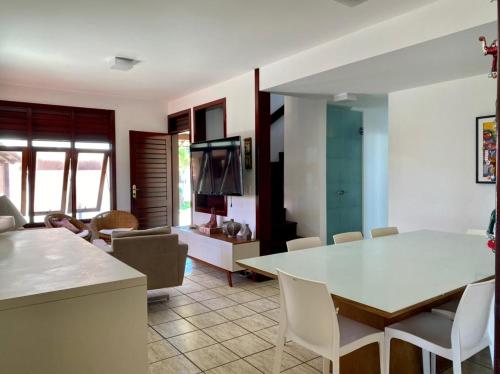 a kitchen and living room with a table and chairs at CASA BEIRA MAR NA BARRA DE SÃO MIGUEL in Barra de São Miguel
