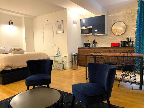 une chambre avec un lit, une table et des chaises dans l'établissement My Trip in Paris - Martin, à Paris