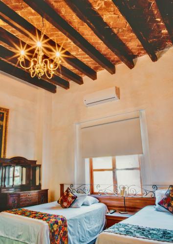 a bedroom with two beds and a chandelier at Los Camilos in Mexico City