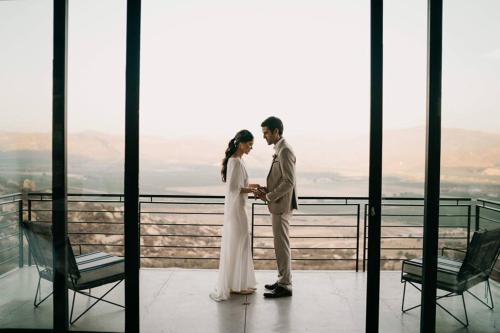 a bride and groom standing on top of a building at Encuentro Guadalupe in Valle de Guadalupe