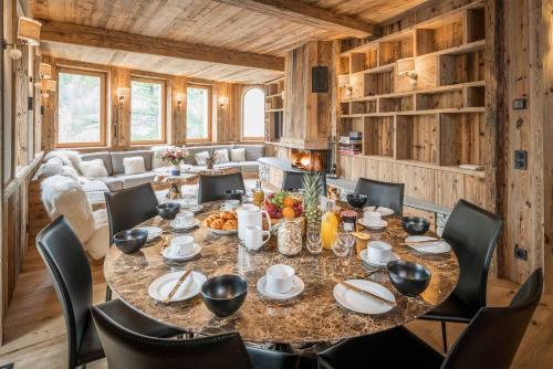 une salle à manger avec une grande table et des chaises dans l'établissement Madame Vacances Chalet Inuit, à Val dʼIsère
