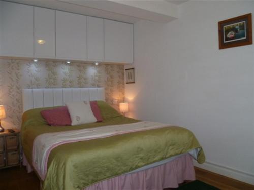 1 dormitorio con 1 cama con manta verde en Mill Wharf, en Berwick-Upon-Tweed