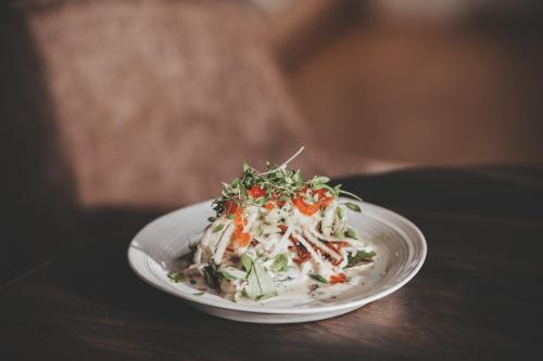 a white plate with a salad on a table at Siljansnäs Hotell in Siljansnäs