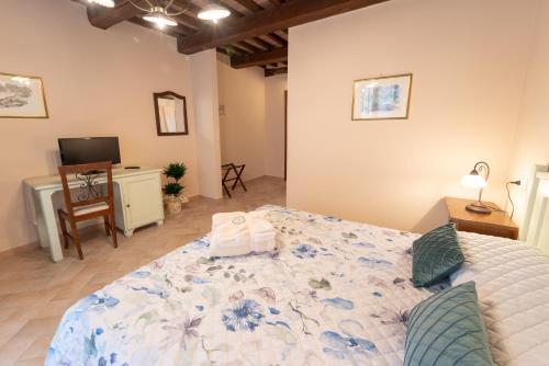 a bedroom with a large bed and a desk at Albergo La Loggia di San Martino in Gualdo Tadino
