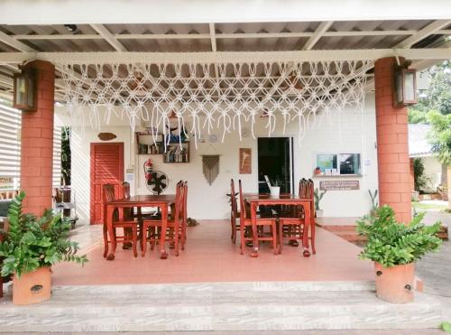 a patio with wooden tables and chairs on it at Samet Bellhouse in Ko Samed
