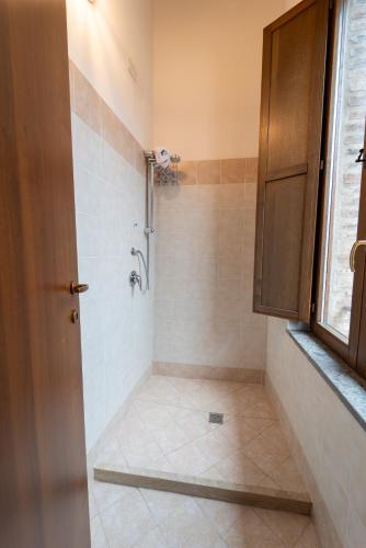 a bathroom with a shower with a tiled floor at Albergo La Loggia di San Martino in Gualdo Tadino