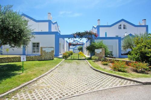 a cobblestone street in front of a white building at CASA ALFARROBA, QUINTA DO PEROGIL, TAVIRA, ALGARVE in Tavira