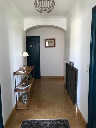 un couloir avec une porte bleue et une table dans l'établissement Chambre d'hôtes à la campagne, à Coings