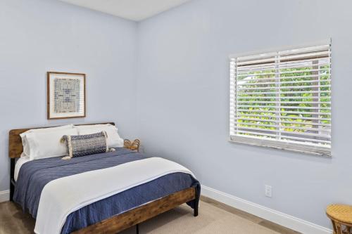 a white bedroom with a bed and a window at Gorgeous Residence on Buttonwood Lane with Bikes in Sanibel