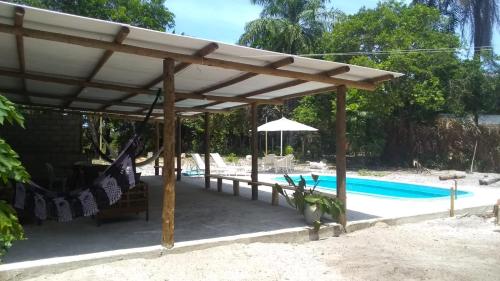 une pergola en bois à côté d'une piscine dans l'établissement RECANTO DE ZEZE - casa 2, à Ilhéus