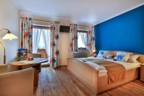 um quarto com uma cama grande e uma parede azul em Gästehaus Heißenlehen em Ramsau