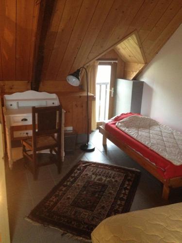 une chambre avec un lit, un bureau et une lampe dans l'établissement Les Chambres d'hôtes d'Adèle, à Quemper-Guézennec