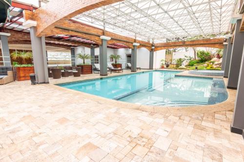 a swimming pool in a building with a ceiling at Sonesta Hotel Loja in Loja