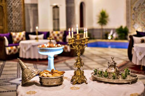 a room with a table with a candlestick and candles at Riad Marjana suites & Spa in Fez
