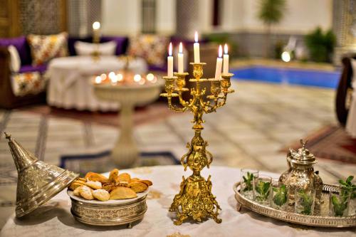 a table with a candlesticks and a plate of food at Riad Marjana suites & Spa in Fez