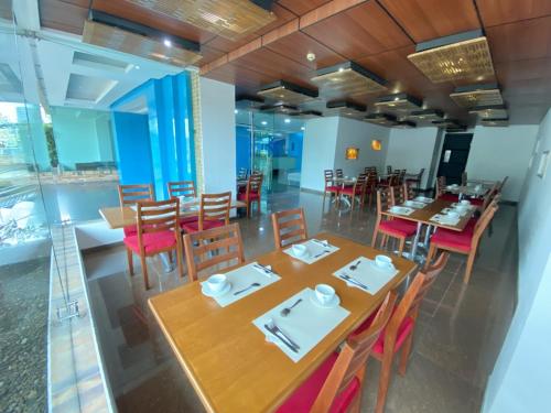 a dining room with wooden tables and chairs at Atlantic Garden Hotel in Barranquilla