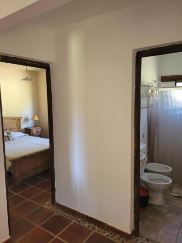 a bathroom with a toilet and a bed and a mirror at Casa de campo in Santa María