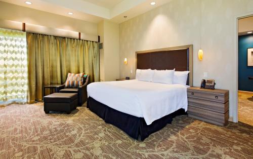 a hotel room with a bed, chair, and nightstand at Sky Ute Casino Resort in Ignacio