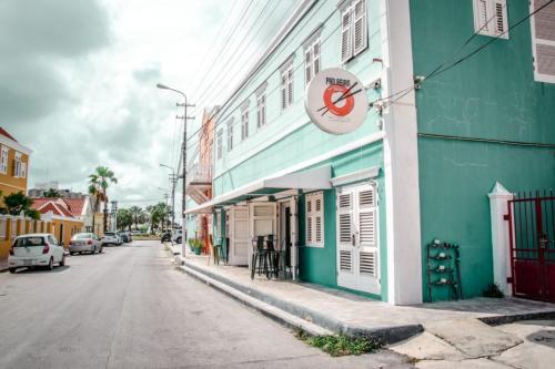 a street with a green building with a no parking sign on it at Bed & Bike Curacao in Willemstad