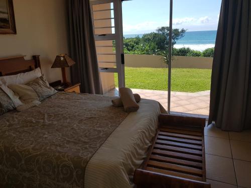 a bedroom with a bed and a view of the ocean at 3 Marina Palms, Woodgrange-on-sea in Hibberdene