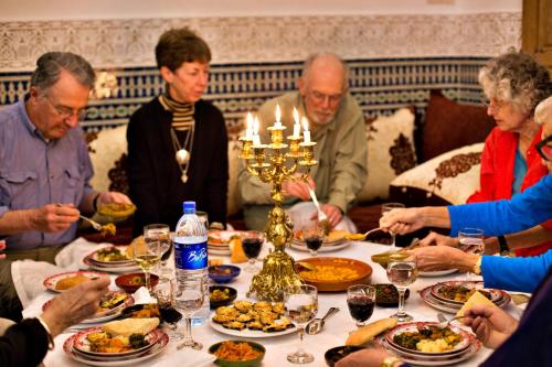 a group of people sitting around a table eating food at Riad Marjana suites & Spa in Fez