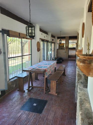 a room with a table with benches and windows at Casona de campo in Santa María