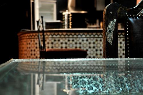 uma mesa de vidro com uma cadeira em frente a um balcão em Luxury Riad Saad Fes- Apart em Fez