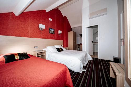 a hotel room with two beds and red walls at Hôtel Le Tivoli in Vic-en-Bigorre