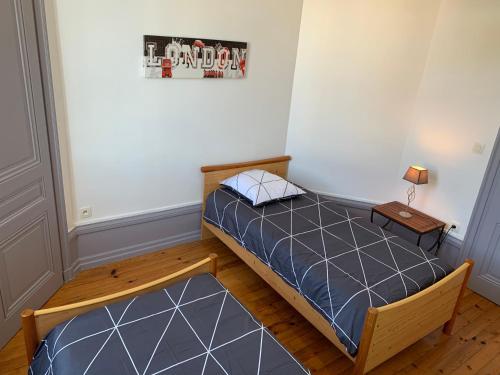 een kleine slaapkamer met een bed en een tafel bij Appartement de la République in La Tour-du-Pin