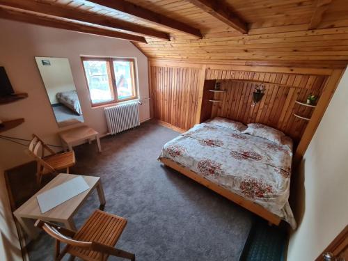 1 dormitorio con 1 cama en una habitación de madera en Casa David, en Sinaia
