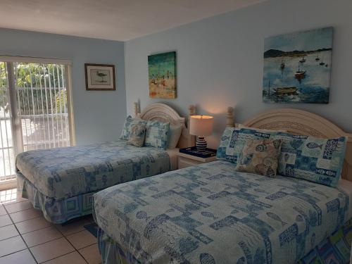 een slaapkamer met 2 bedden en een raam bij Turtle Crawl Inn - Longboat Key in Longboat Key