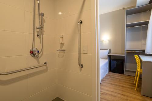 a shower stall in a bathroom with a table at Transamerica FIT Primavera do Leste in Primavera do Leste